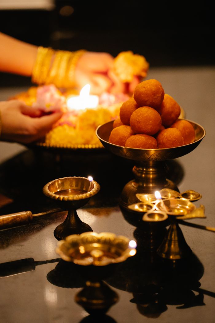A display of Indian sweets with candlelight ambiance for festive celebration.